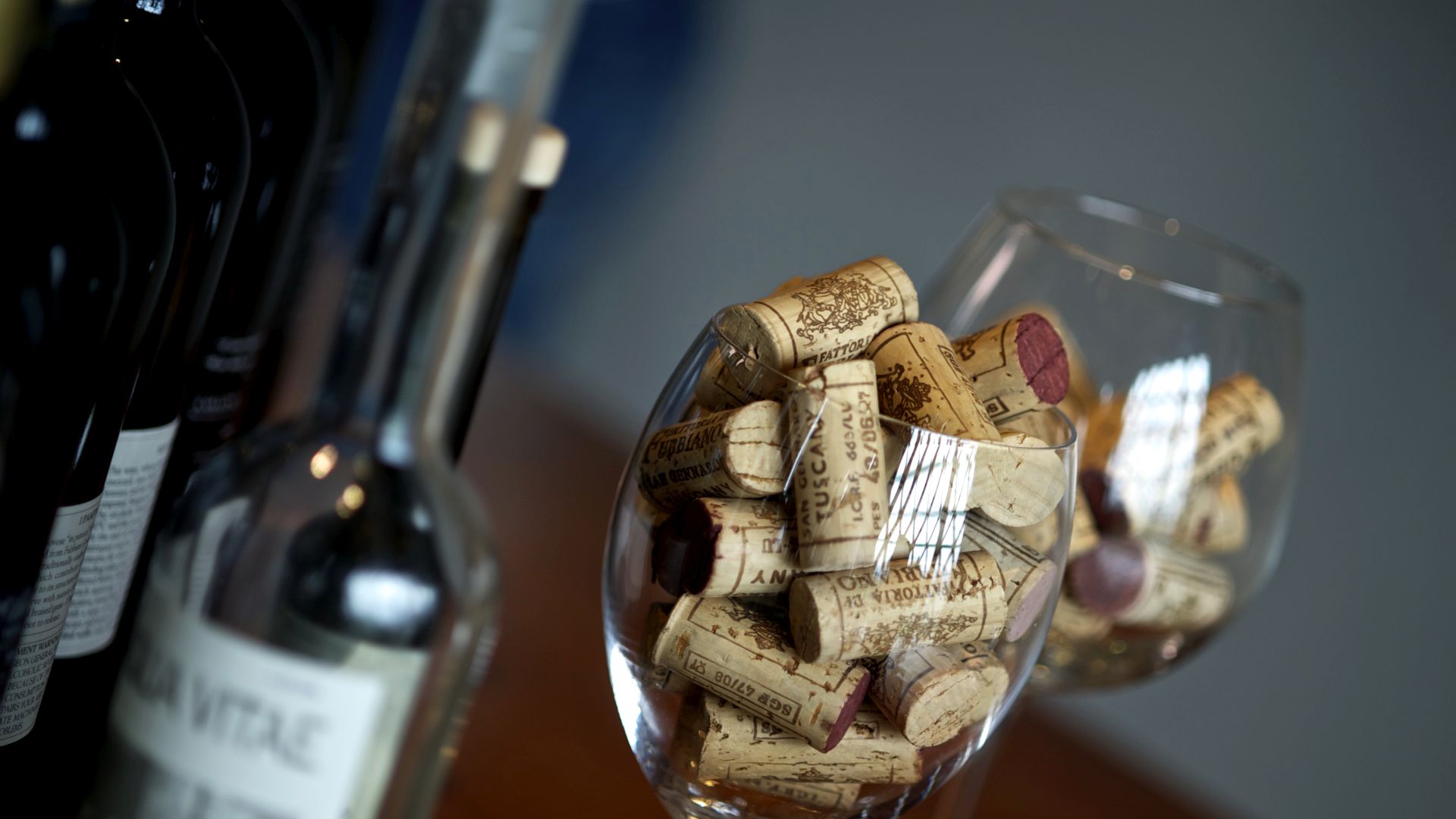 una bottiglia di vino e un calice pieno di tappi