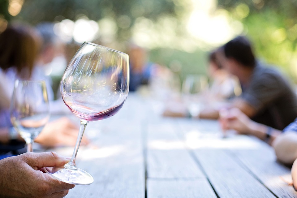 personnes au tour d'une table ou on bois du vin